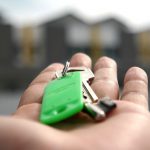 house key held in palm of hand and street in Houston TX
