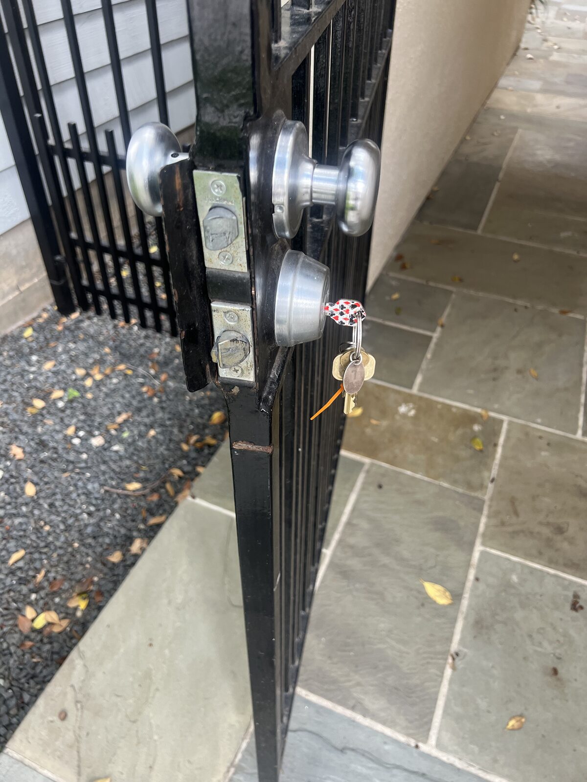 New knob and deadbolt security locks installed on a metal gate door