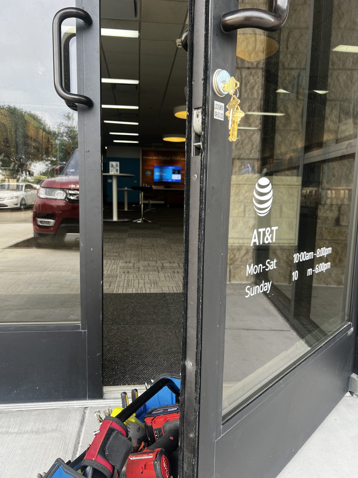 Locksmith tools and new cylinder during a storefront door lock repair