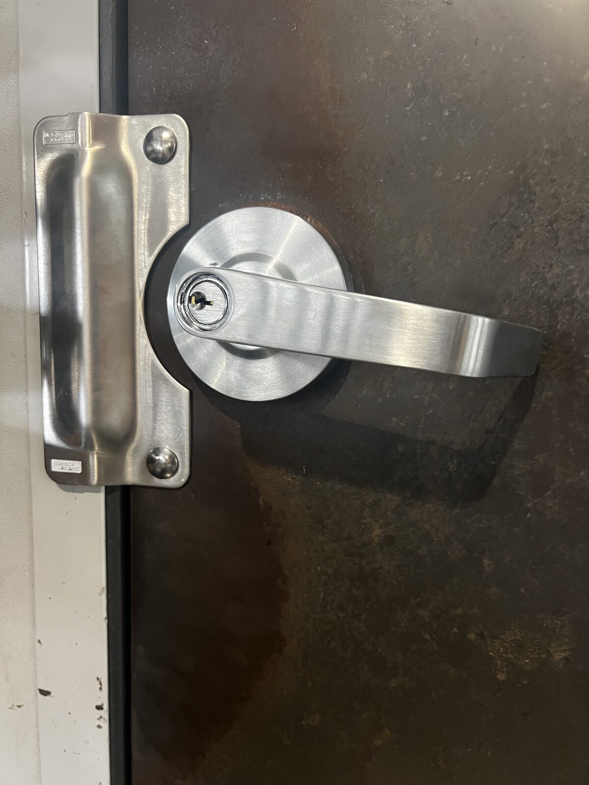 Commercial lever lock with latch guard on a steel door