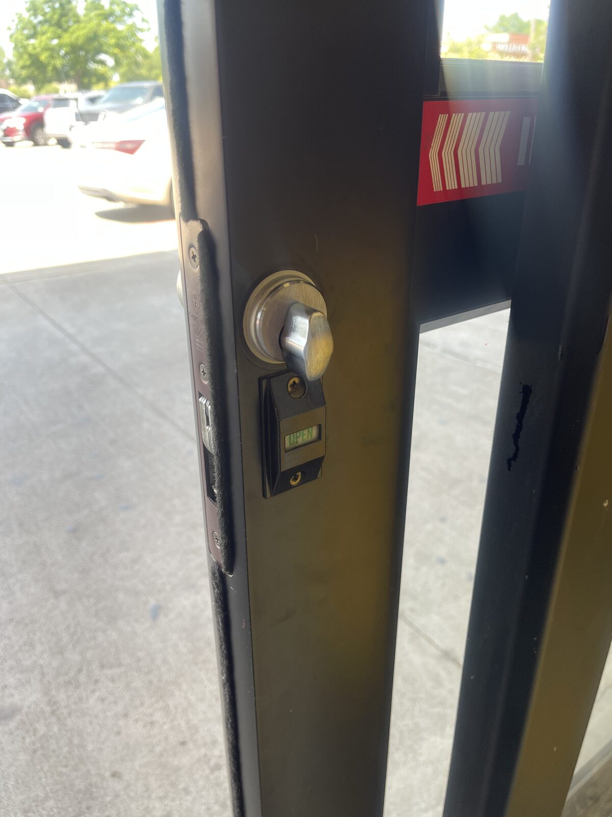 Storefront door lock with occupancy indicator installed on aluminum stile door in Houston