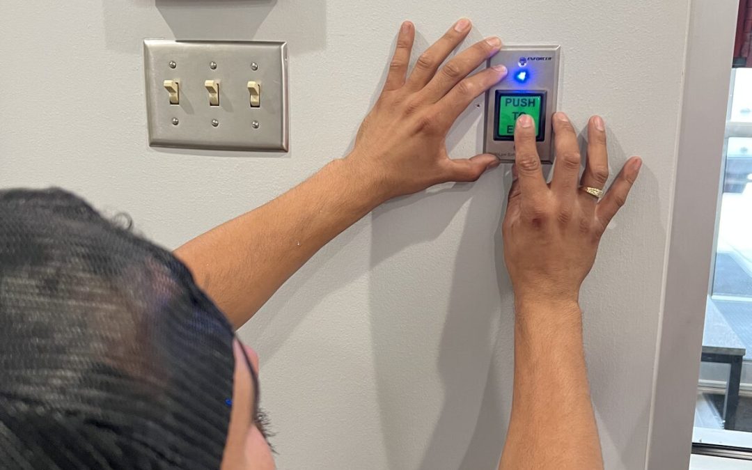 Technician installing an access control reader on an office wall in Houston