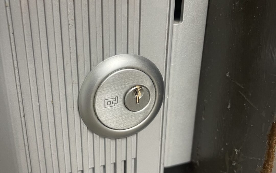Exit alarm lock housing with key cylinder on a commercial door