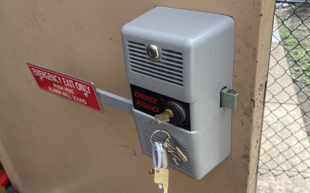 Alarmed emergency exit lock with exit-only sign on a steel door in Houston