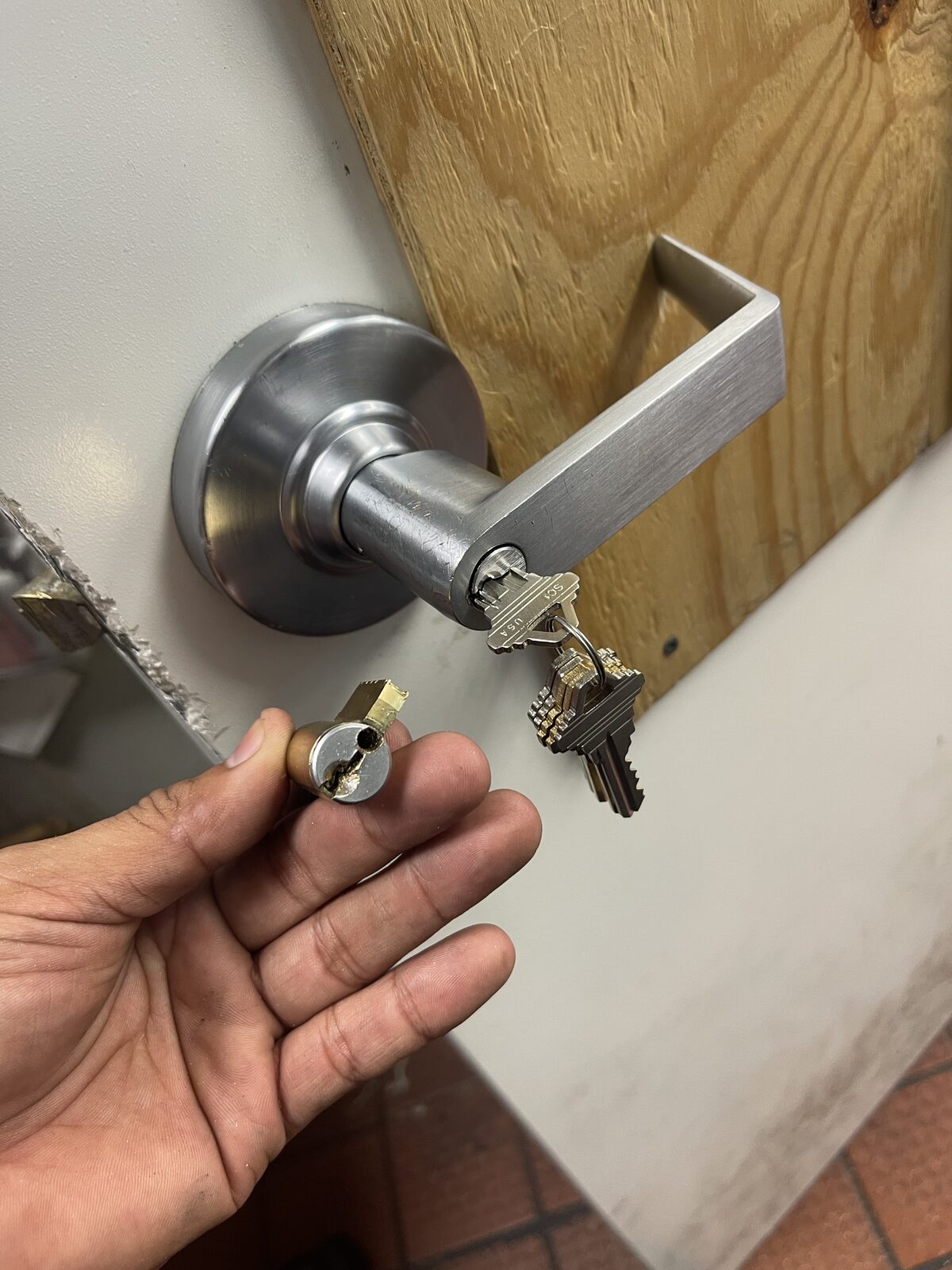 Lever lock cylinder removed for rekeying on a commercial door in Houston