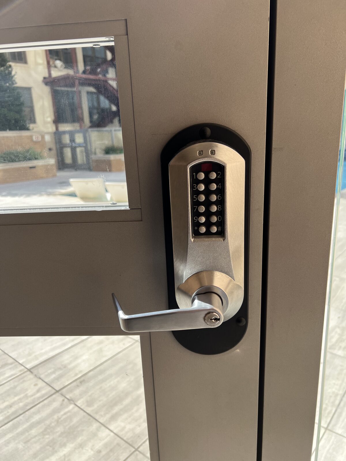 Electronic pushbutton keypad lever lock on a commercial aluminum door in Houston