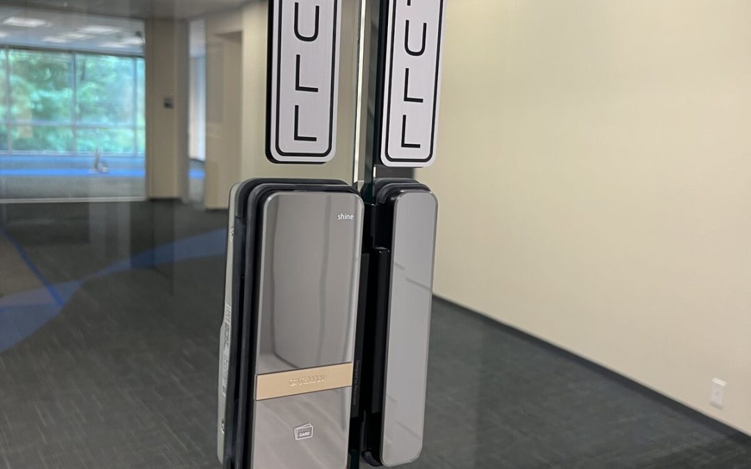 Smart lock installed across frameless glass office doors in Houston