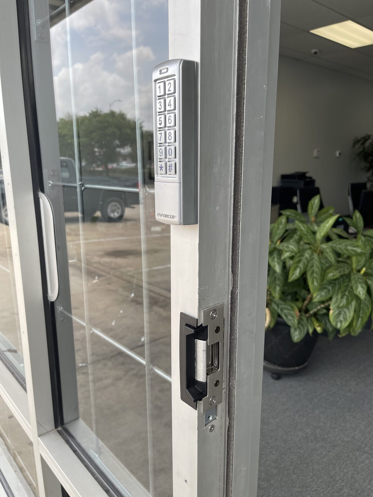 Access control keypad and electric strike on an aluminum storefront door in Houston