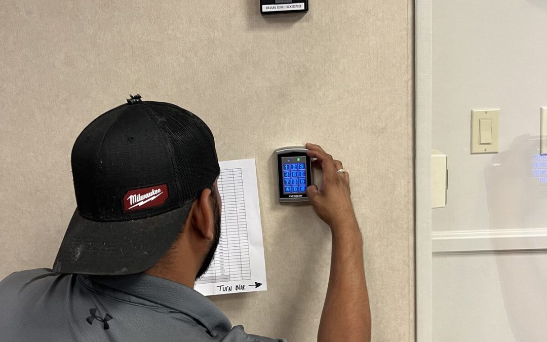 Technician installing an access control reader on an office wall in Houston