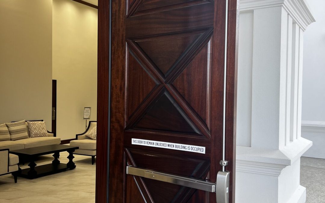 Wood entry door with exit device and door closer at a Houston business